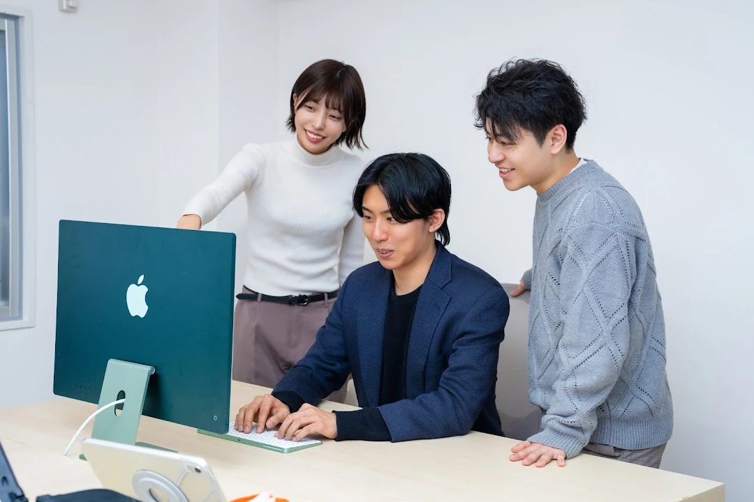 PCの画面を囲んで話し合うONE WILLのメンバー